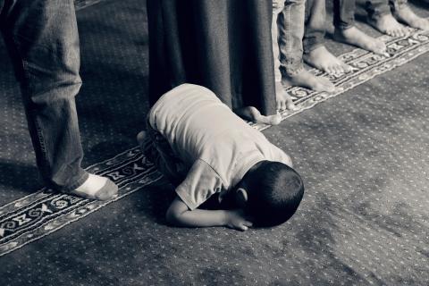 Young child forced to kneel and pray